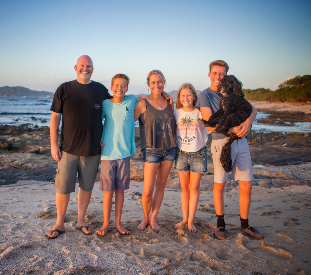 Matt and Erin Sampson with their three kids and their dog on the beach in Tamarindo at sunset