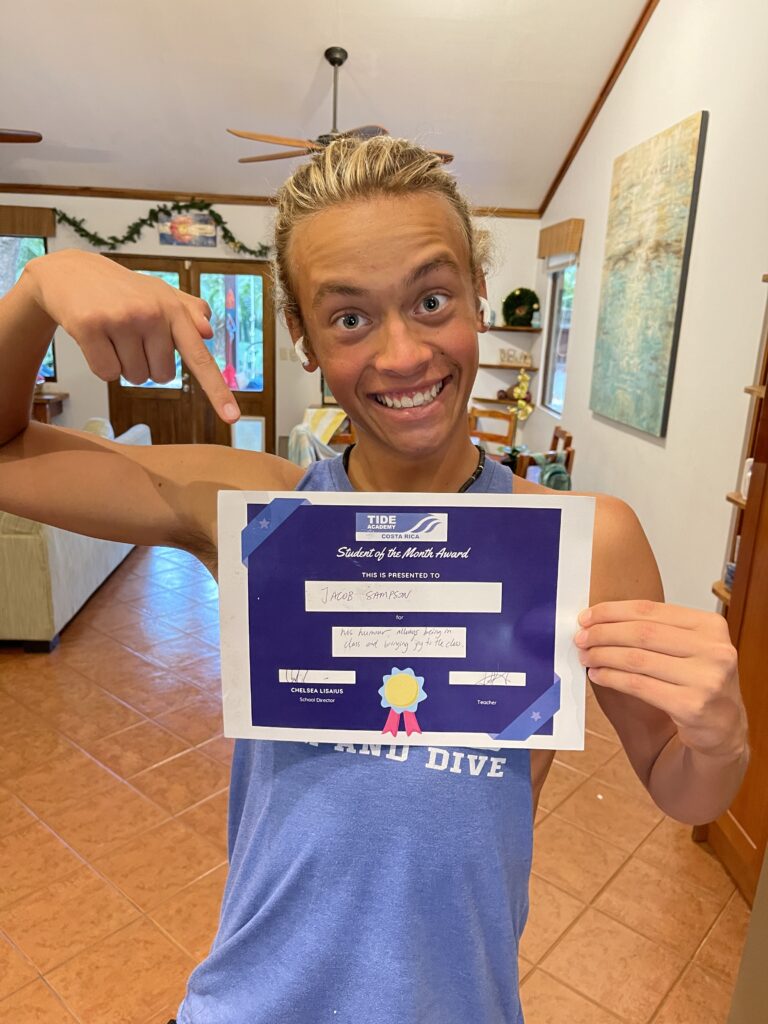 Jacob Sampson pointing at his TIDE Academy Student of the Month award